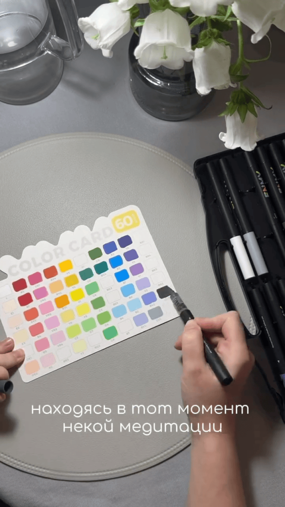 Hand filling a green square on a color card with an ENMY acrylic marker.