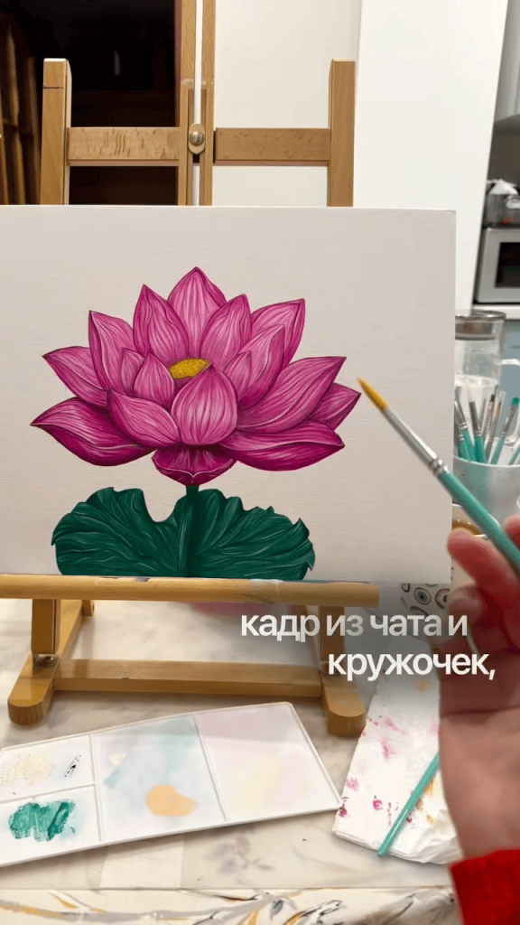 Unfinished lotus flower painting on a peach background with gold halo, shown together with two smaller artworks on a table.
