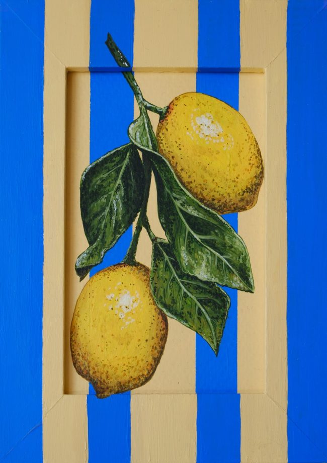 Close view of a gouache painting of two yellow lemons with green leaves on a blue and cream striped wooden panel.