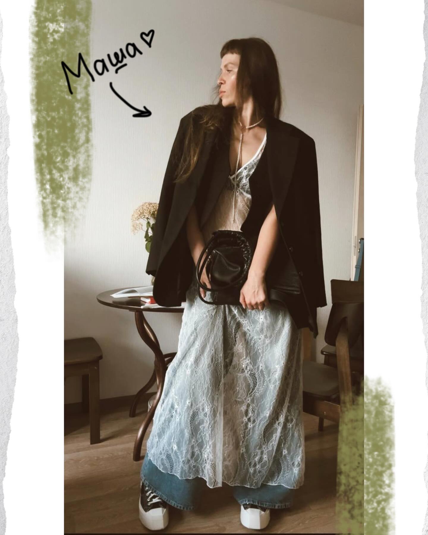Reference photo of Masha standing indoors in an oversized black jacket, lace dress layered over jeans, and white platform shoes.
